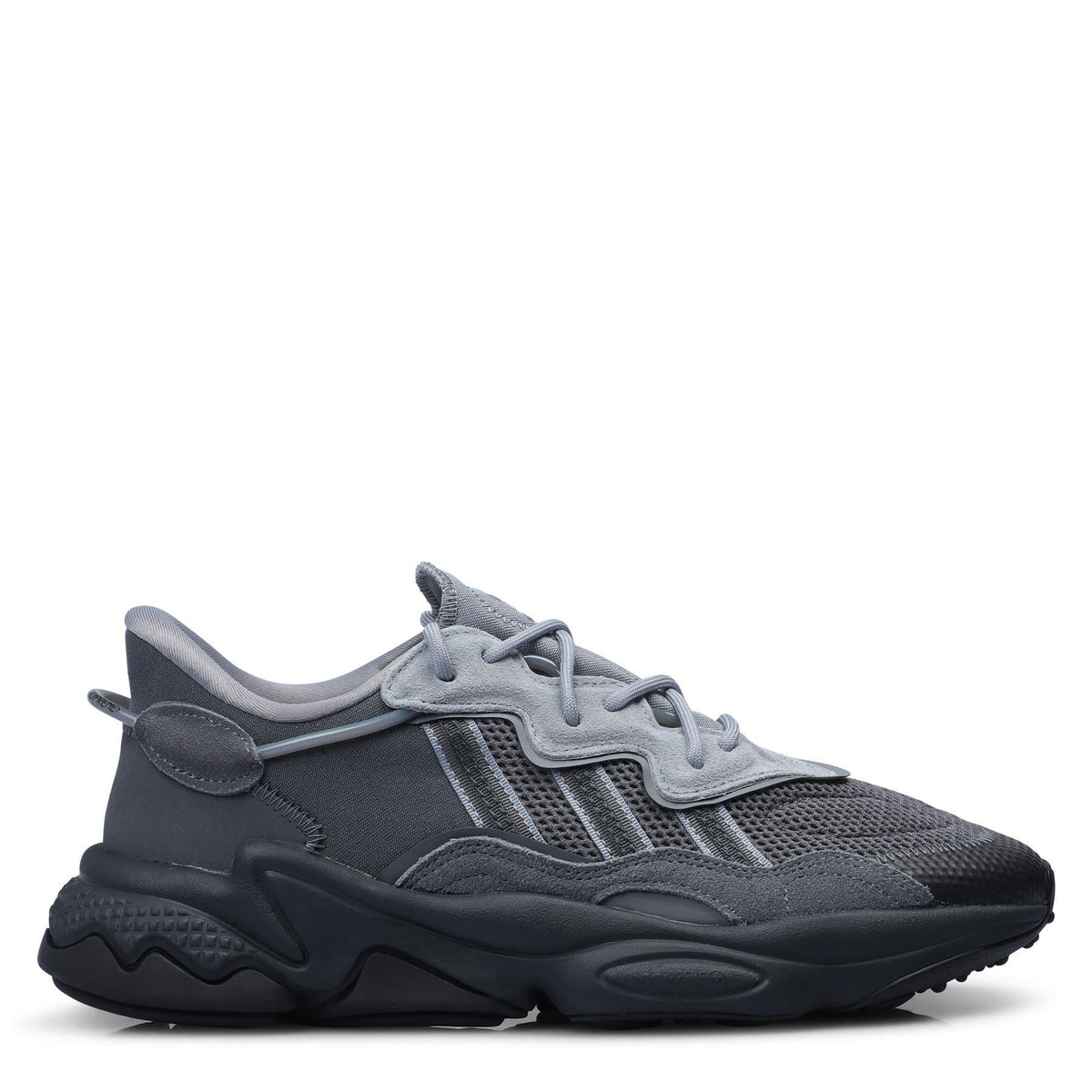 adidas Originals Ozweego trainers in white and black with chunky soles, showcasing sporty footwear design and branding details
