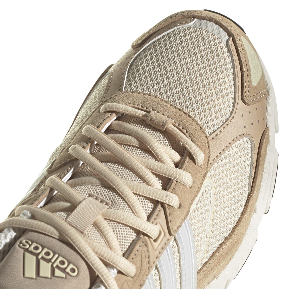 Close-up of sand and off-white laces and mesh upper with stitched overlays and cushioning