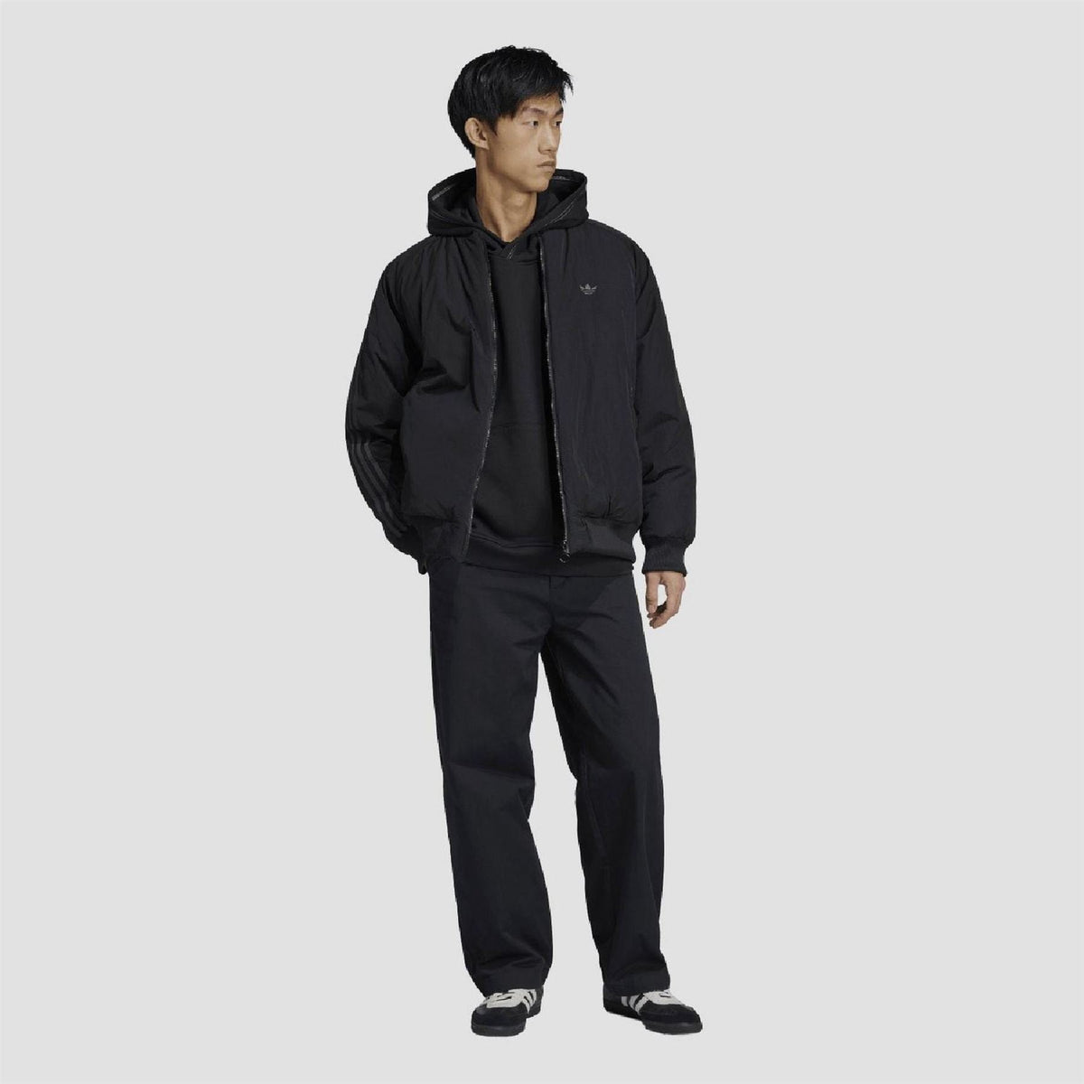 Black adidas Originals hoodie with front pouch pocket and drawstring hood, on model