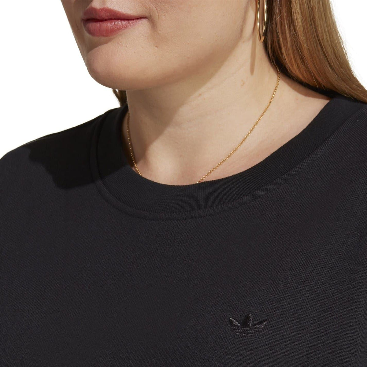Black cropped sweatshirt close-up with crew neck and small adidas logo