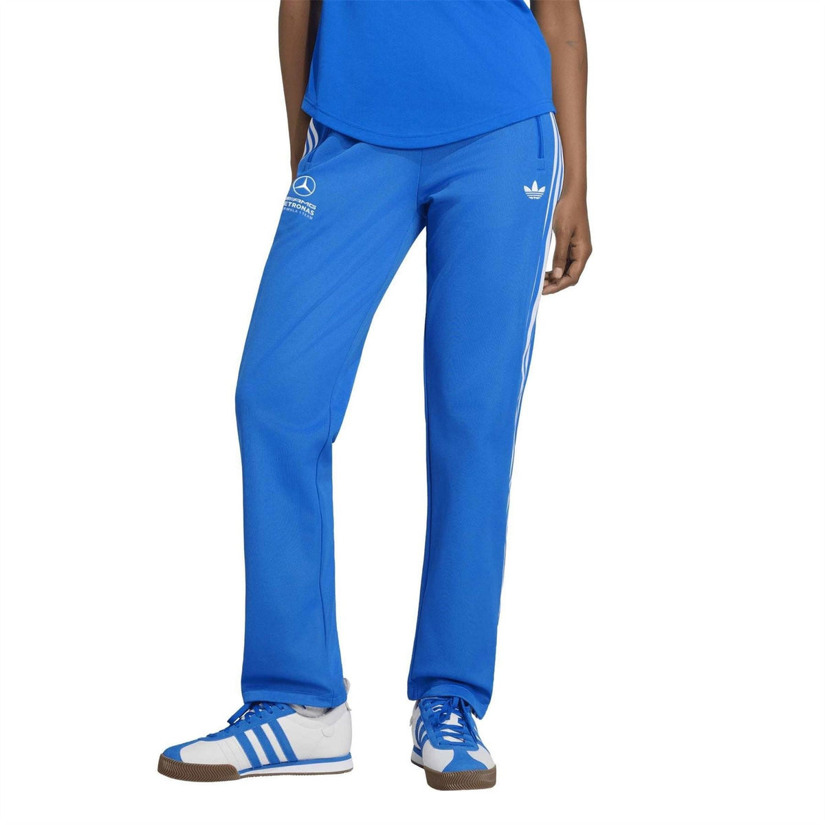 Blue track pants with white side stripes and logo print on the thigh area.