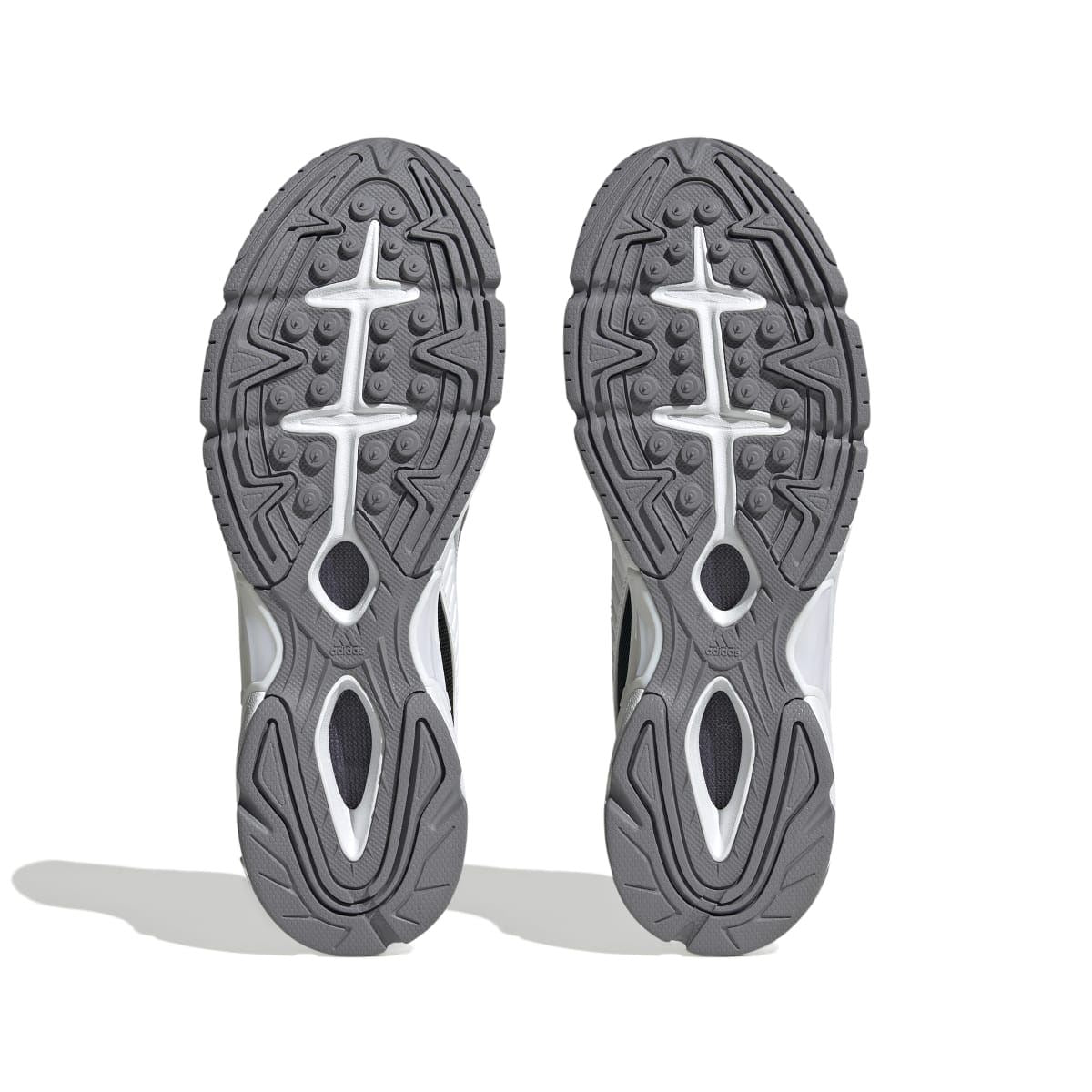 Grey and white sneaker outsoles with patterned tread and oval cutouts