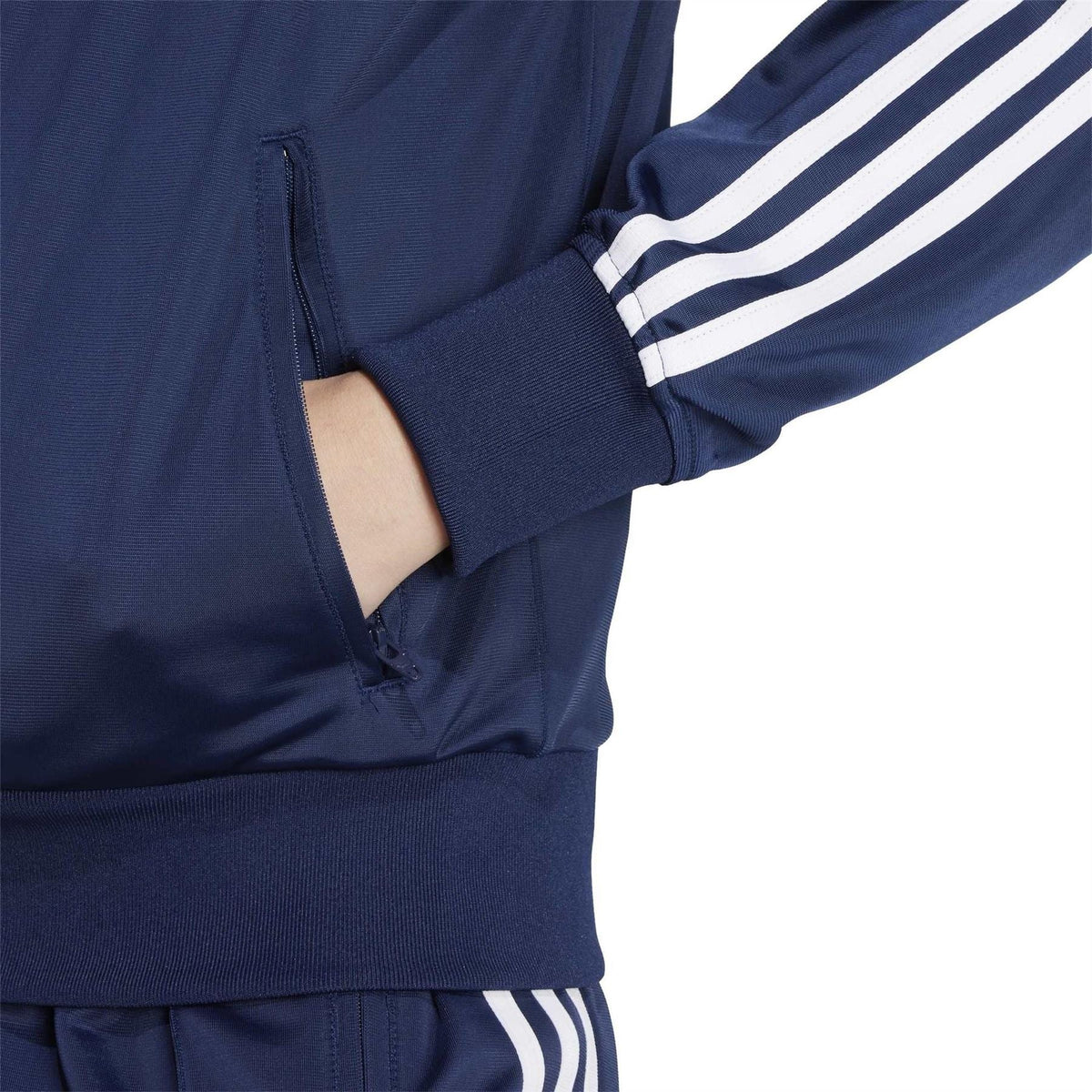 Dark indigo track jacket close-up: full zip, ribbed cuffs, white triple sleeve stripes