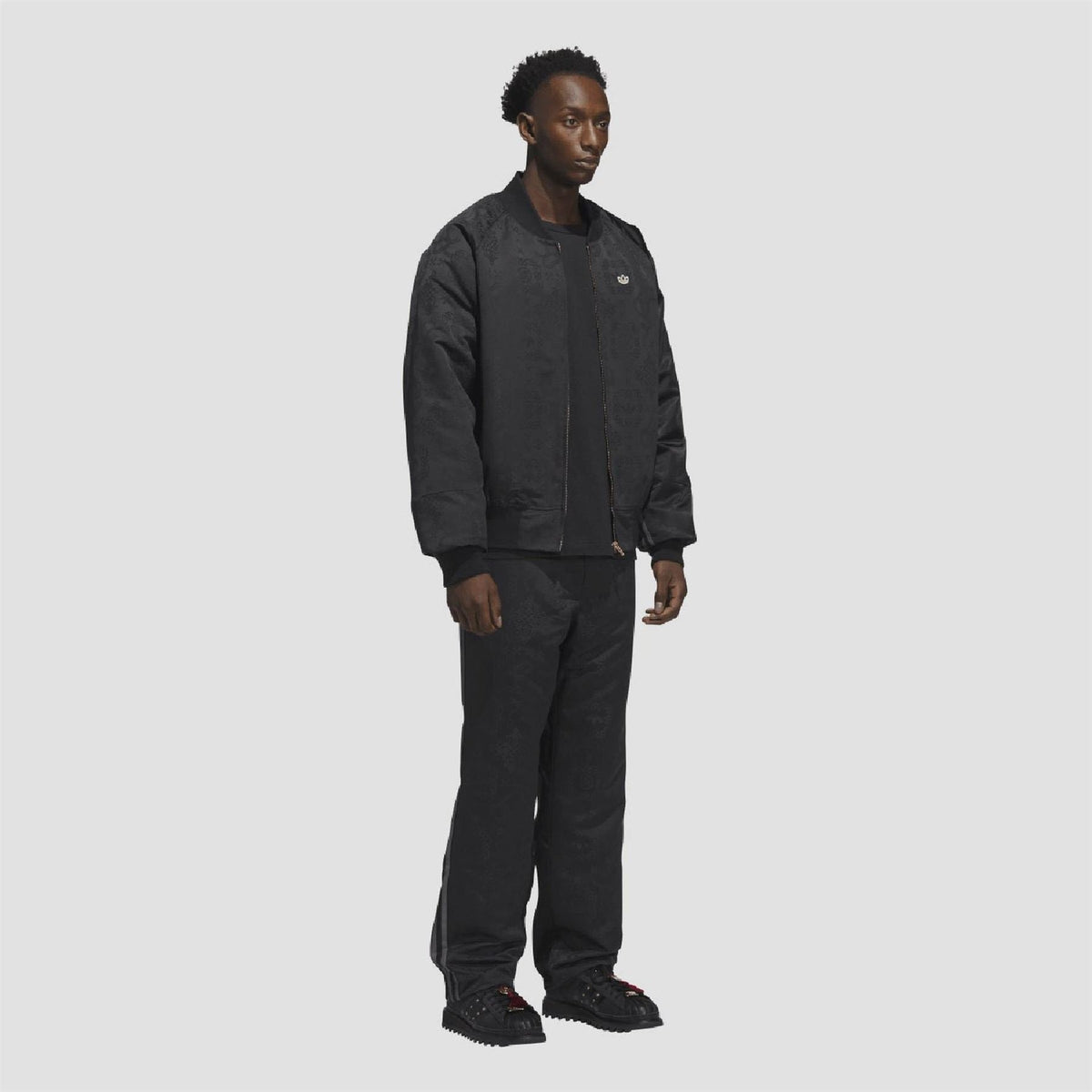 Black adidas track suit bottoms with allover pattern and elastic cuffs