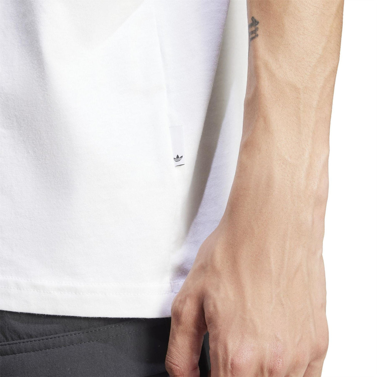 White T-shirt sleeve and hem detail with small adidas logo