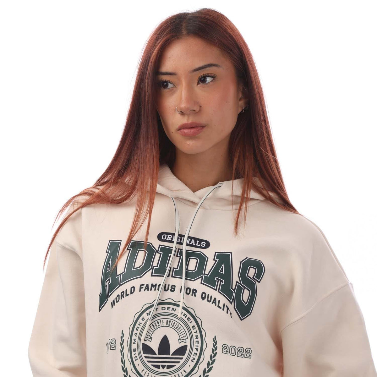 Off-white hoodie close-up with large 'adidas' logo print, drawstring hood