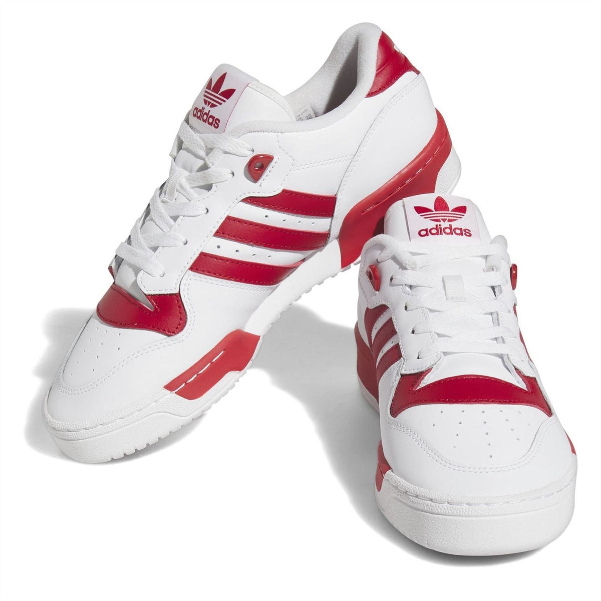 White adidas Originals Rivalry low-top trainers with red laces, heel tabs, and Adidas logo
