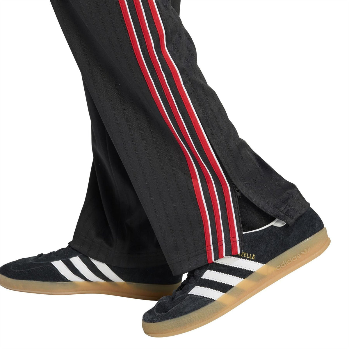 Close-up of black open-hem jogger pants with red-and-white side stripe near shoe