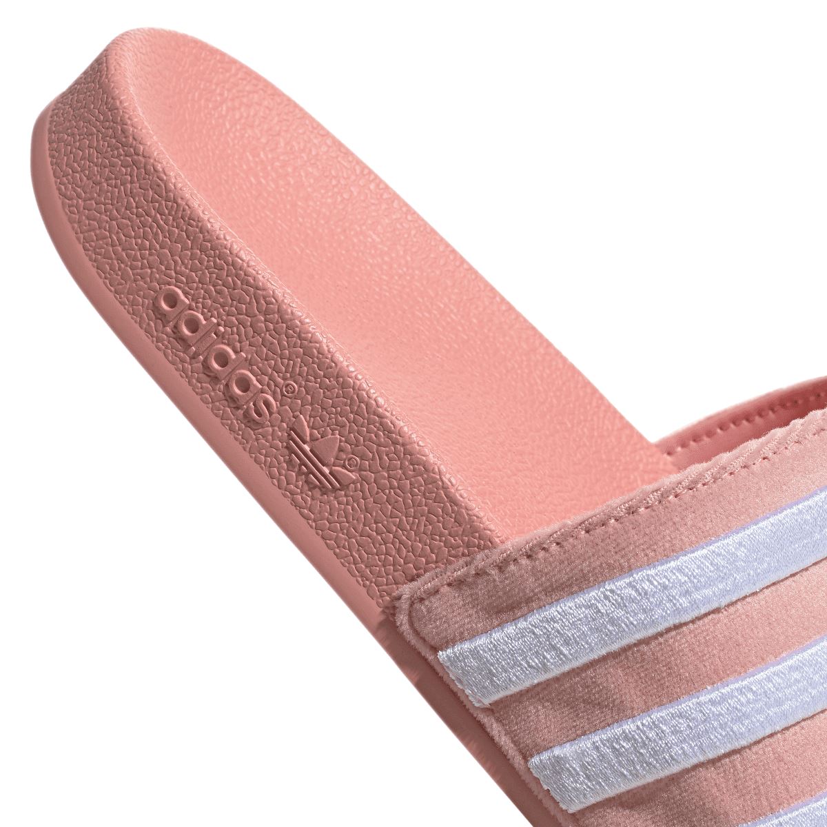 Mauve adidas Adilette footbed close-up with adidas logo and white three-stripe strap