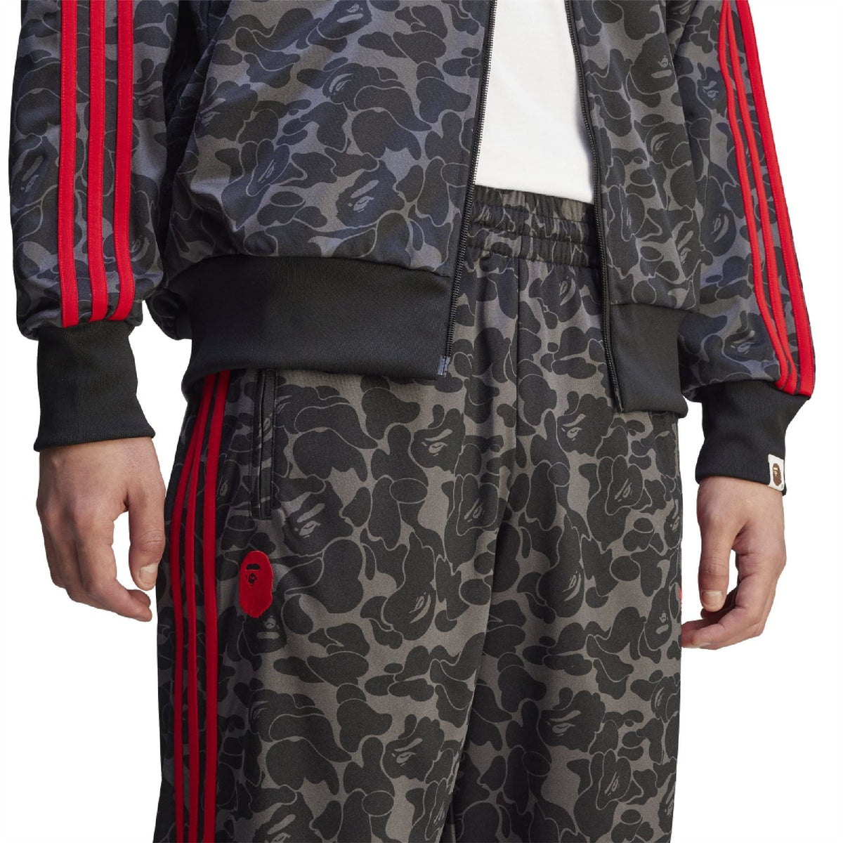Camo trackpants with elastic waistband and red side stripe panel.