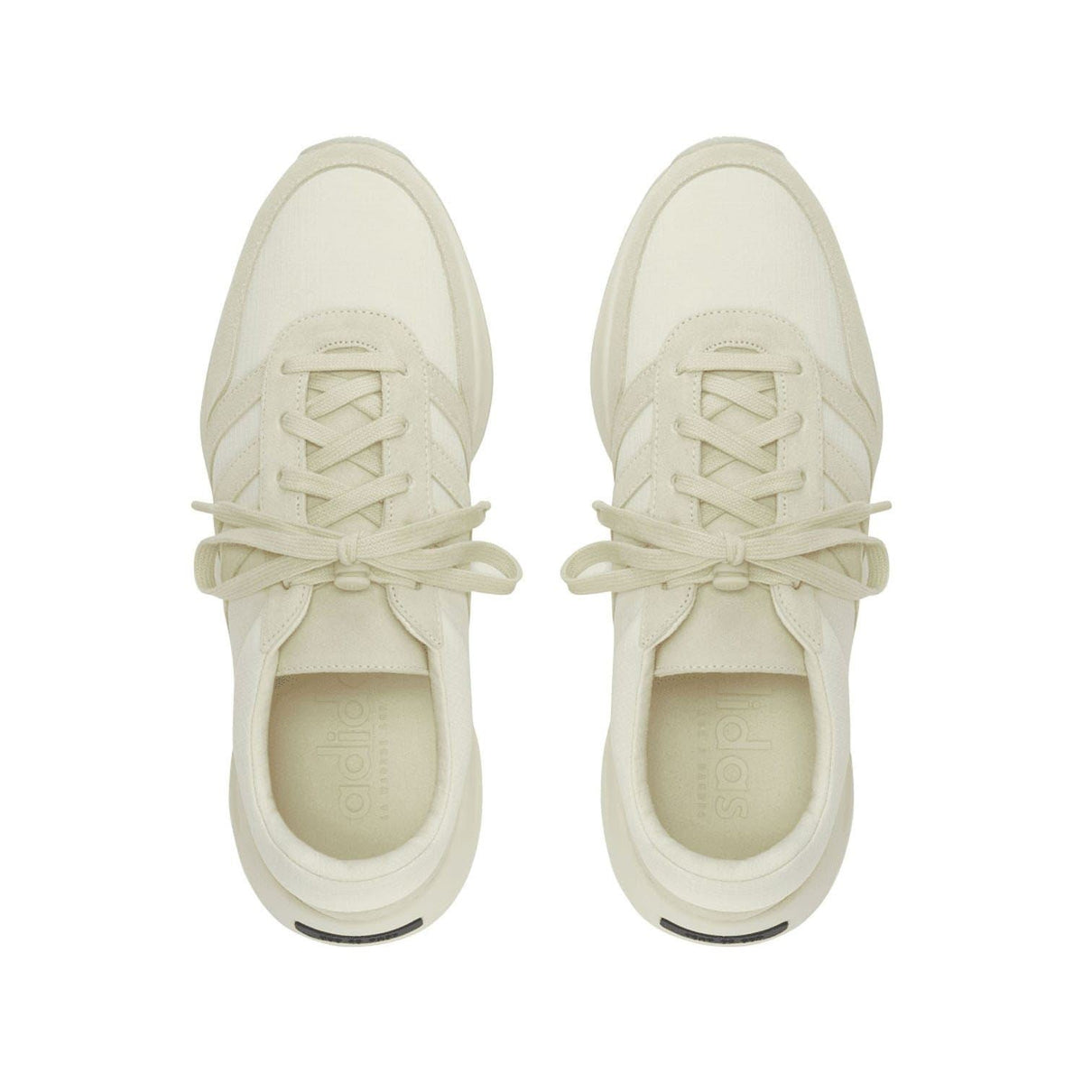 Pair of cream lace-up trainers showing padded tongue and toe caps