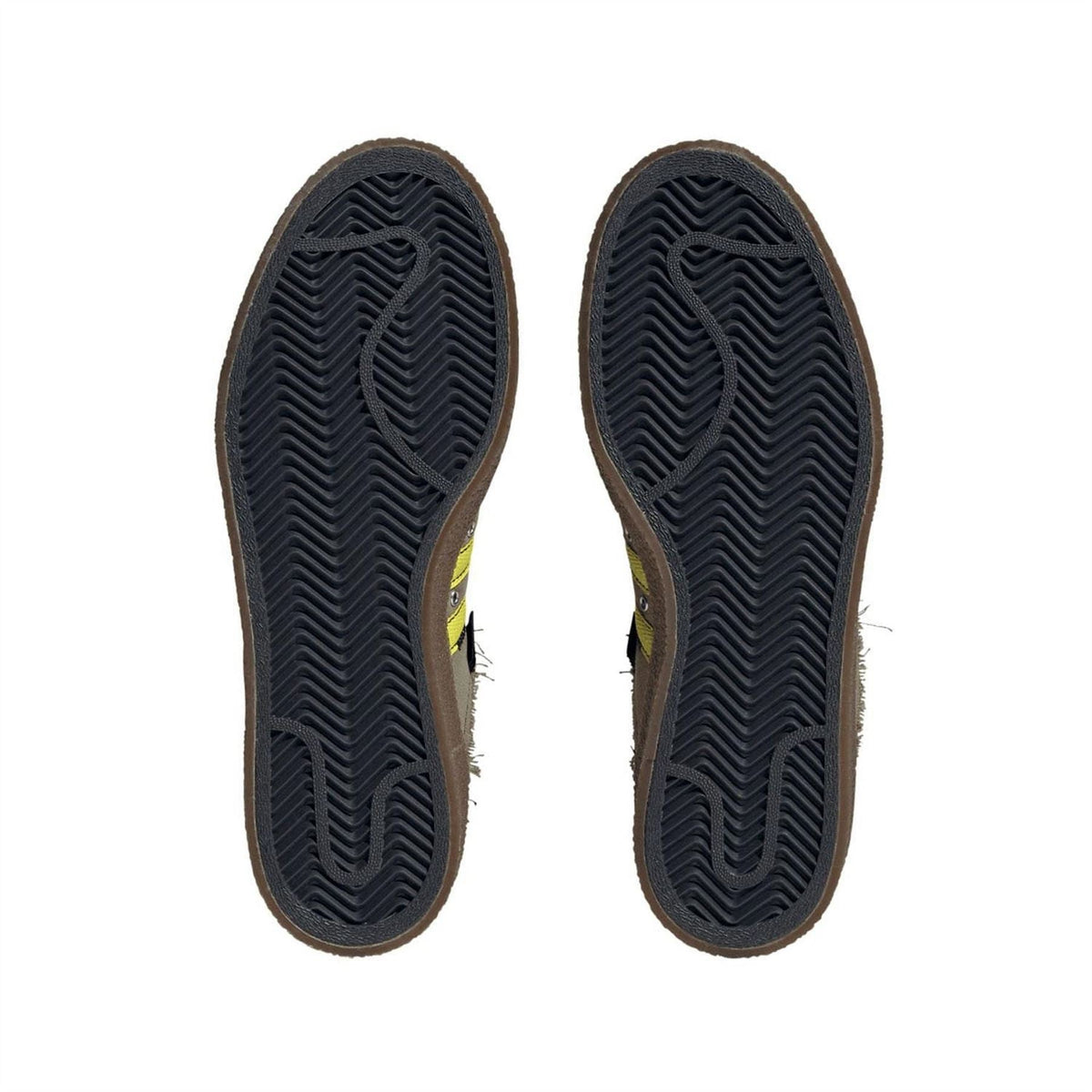 Pair of dark trainer outsoles with zigzag tread pattern
