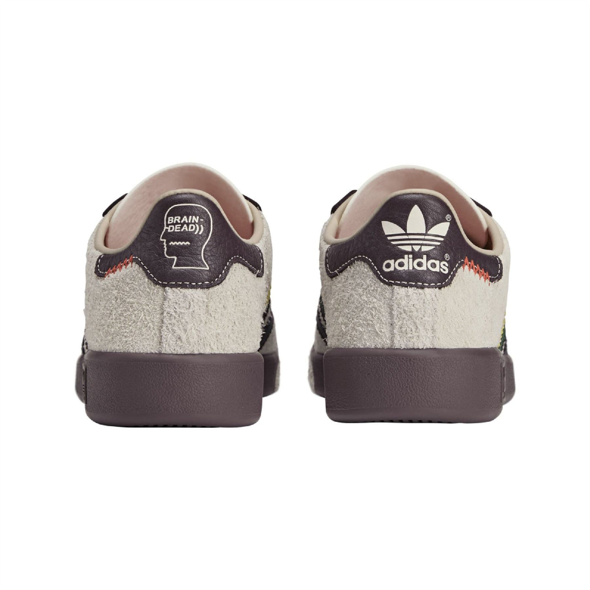 Back view of white suede sneakers with adidas heel patch and brown heel tab