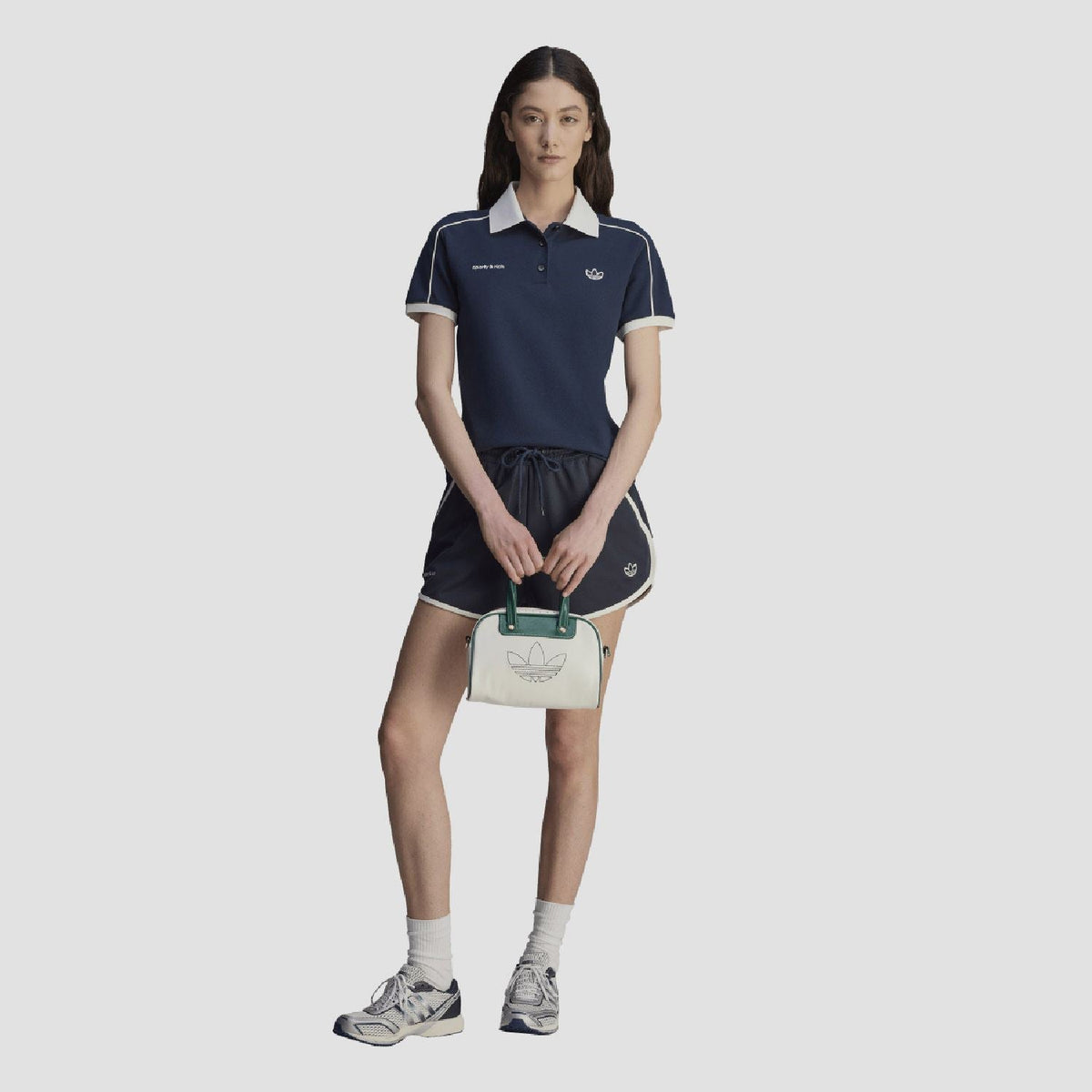 Navy polo shirt with white collar, front crest, and sporty & rich logo