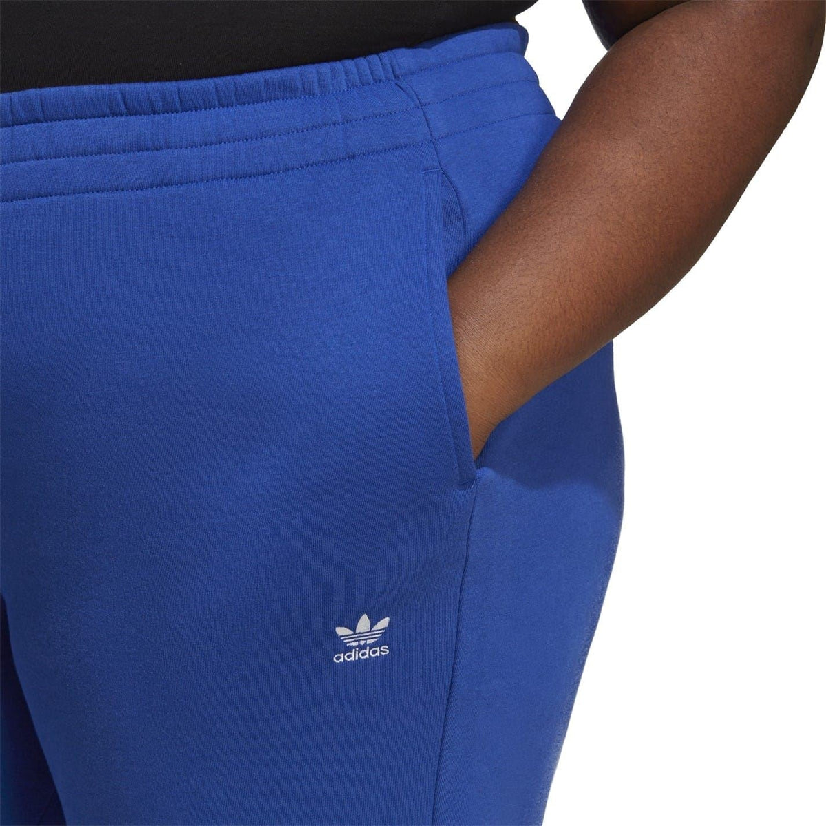 Blue joggers close-up with adidas trefoil logo and elastic waistband