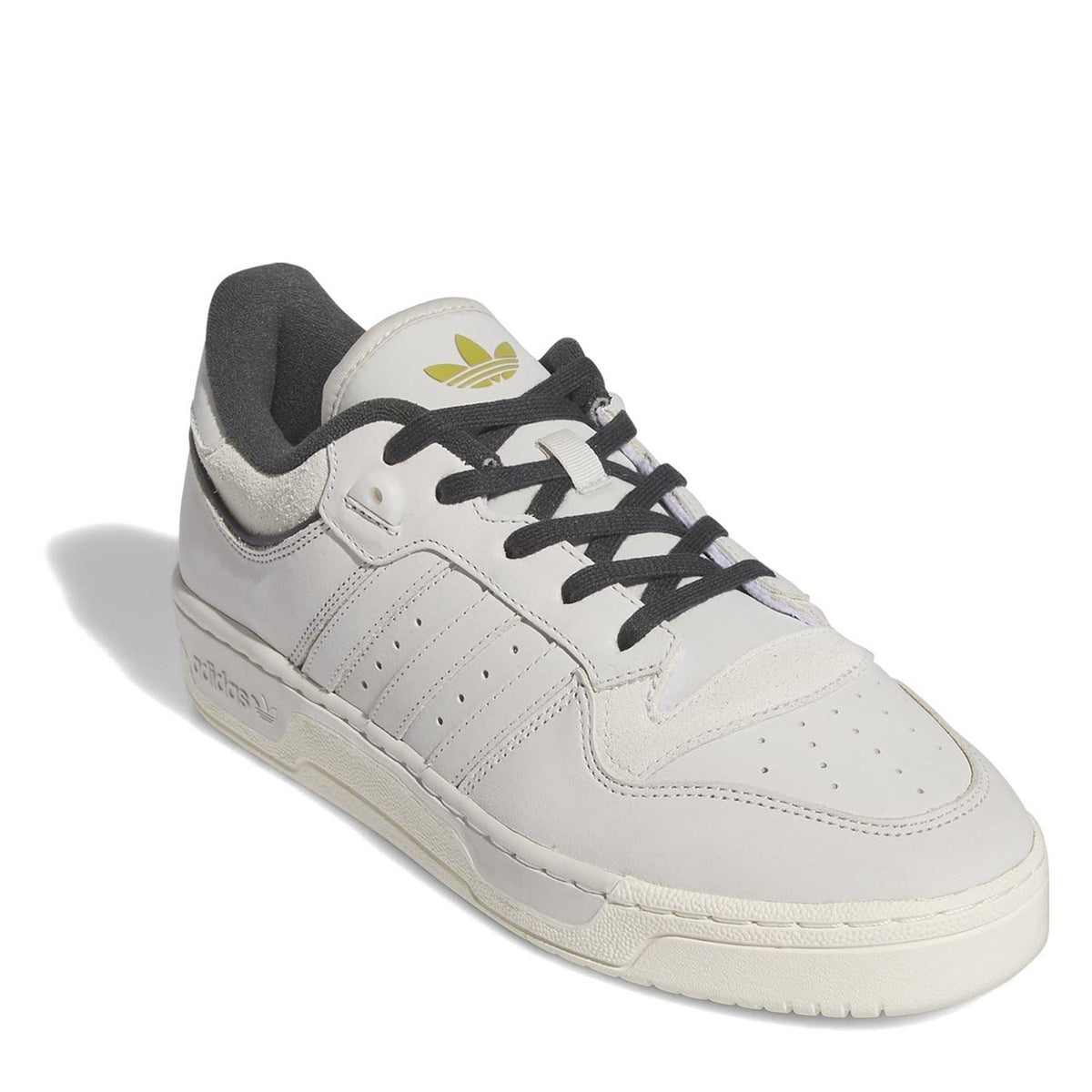 White low-top sneakers with adidas logo on tongue and black lace-up