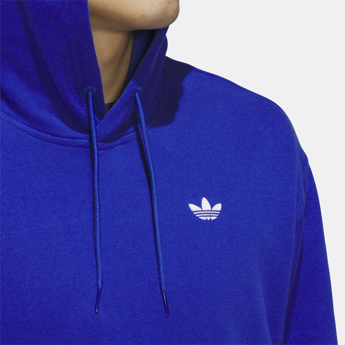 Blue adidas hoodie close-up with trefoil logo and two drawstring hood cords.