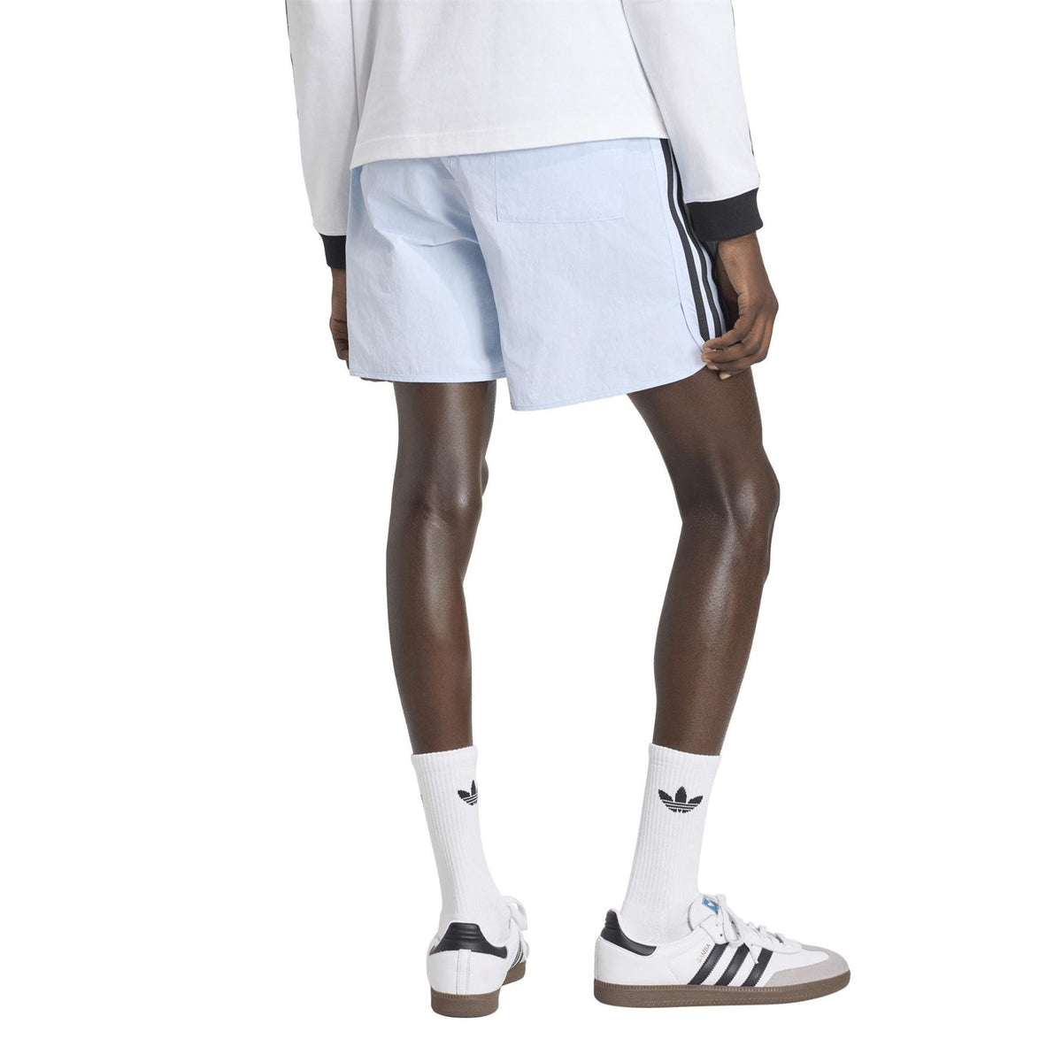 Light blue shorts with elastic waistband and side trefoil logo, above-knee length