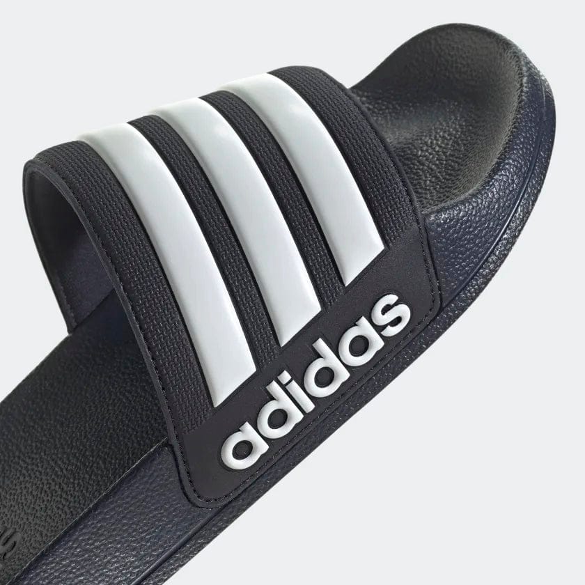 Black shower slide sandals with 3 white adidas stripes on the strap