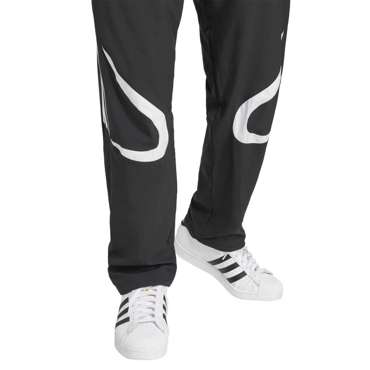 adidas Originals black track pants with large white swoosh-style side graphics