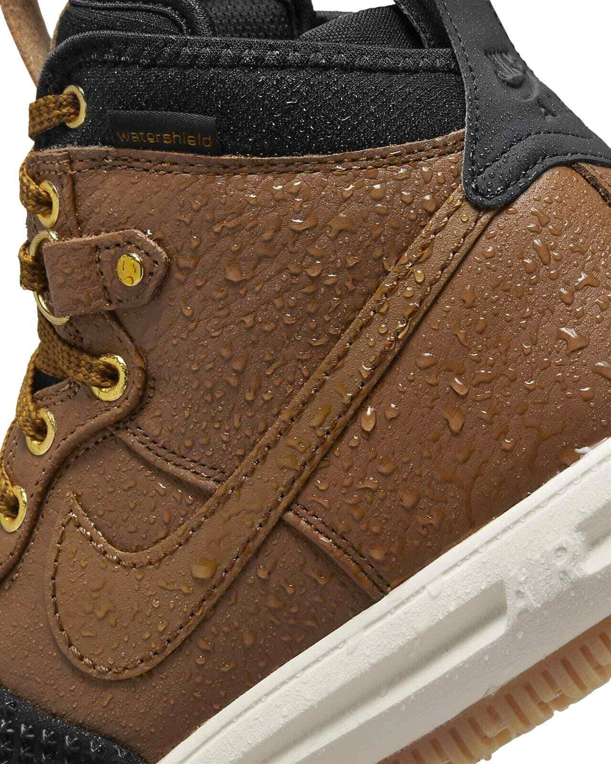Men's Nike duckboot close-up with water droplets on brown leather and black trim