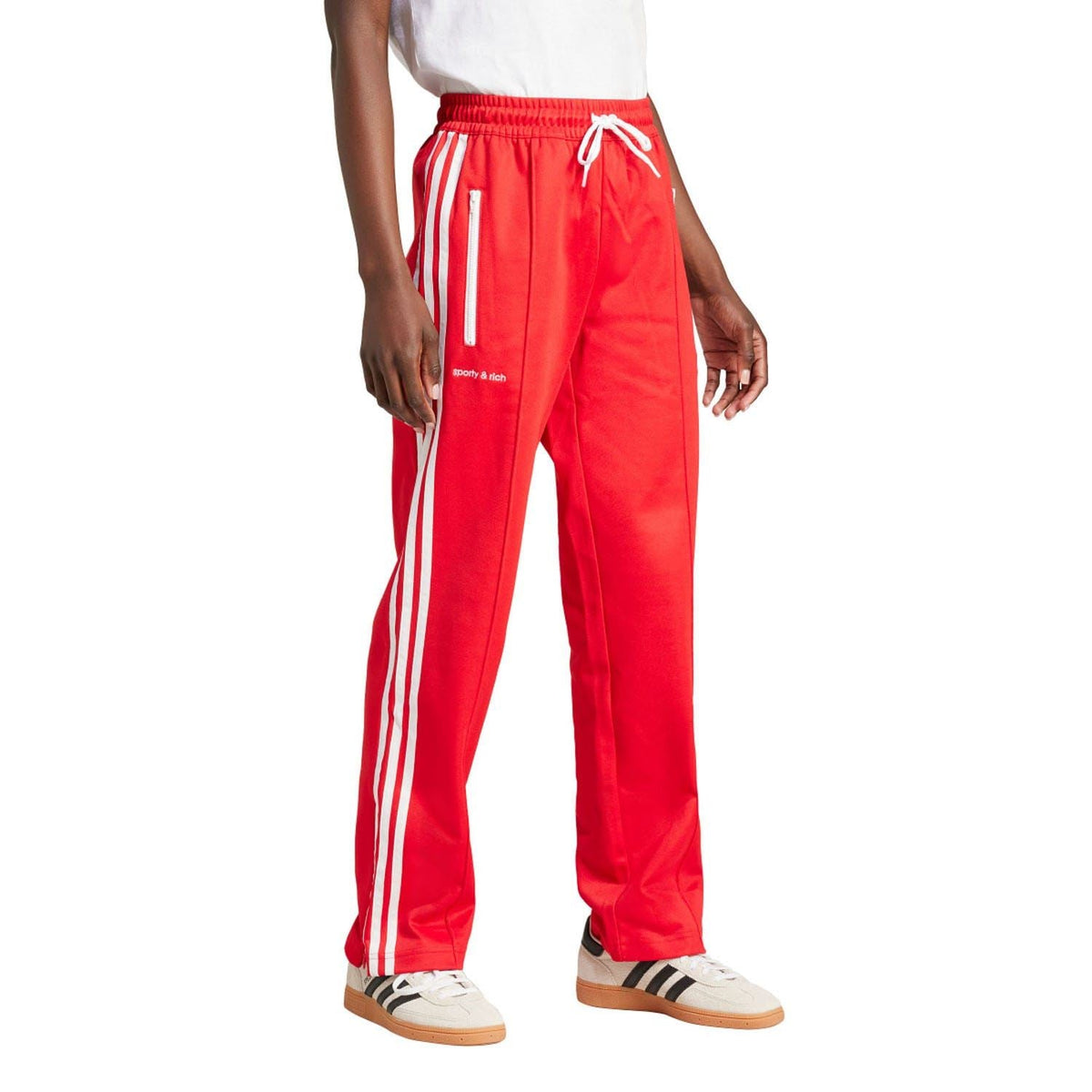 Red adidas track pants with white triple stripes along the sides and elastic cuff hems.