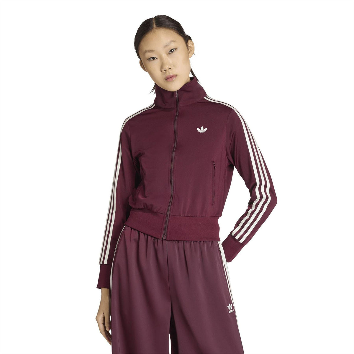 Maroon women’s track jacket with full-zip front, white triple stripes, and chest logo.