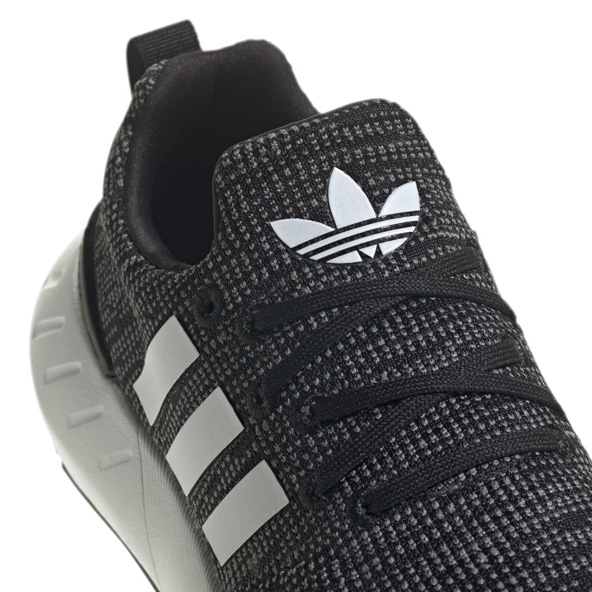 Junior adidas Swift Run 22 trainers close-up, textured black knit with white adidas logo on heel.
