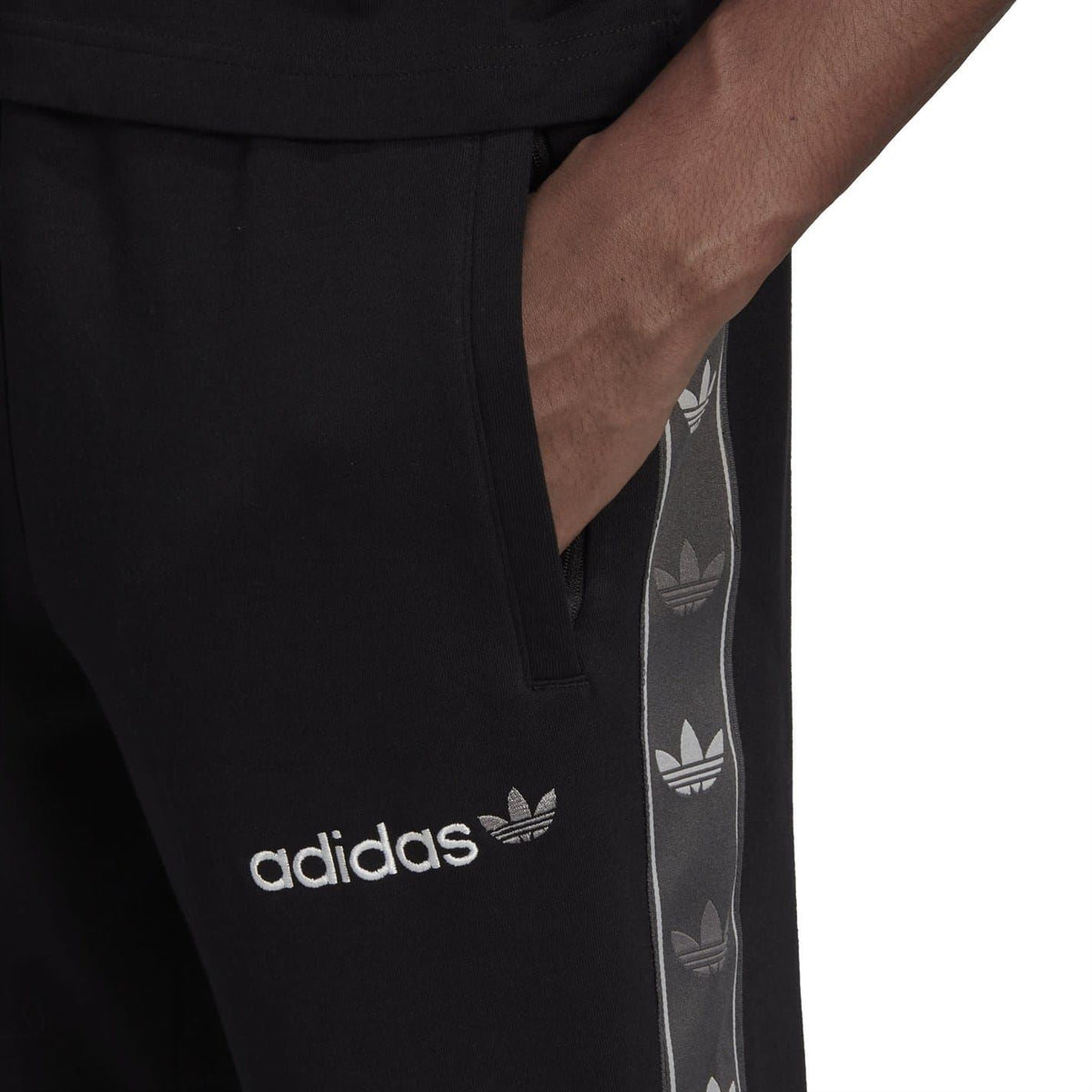 Black adidas Originals joggers close-up with side pocket and logo side tape
