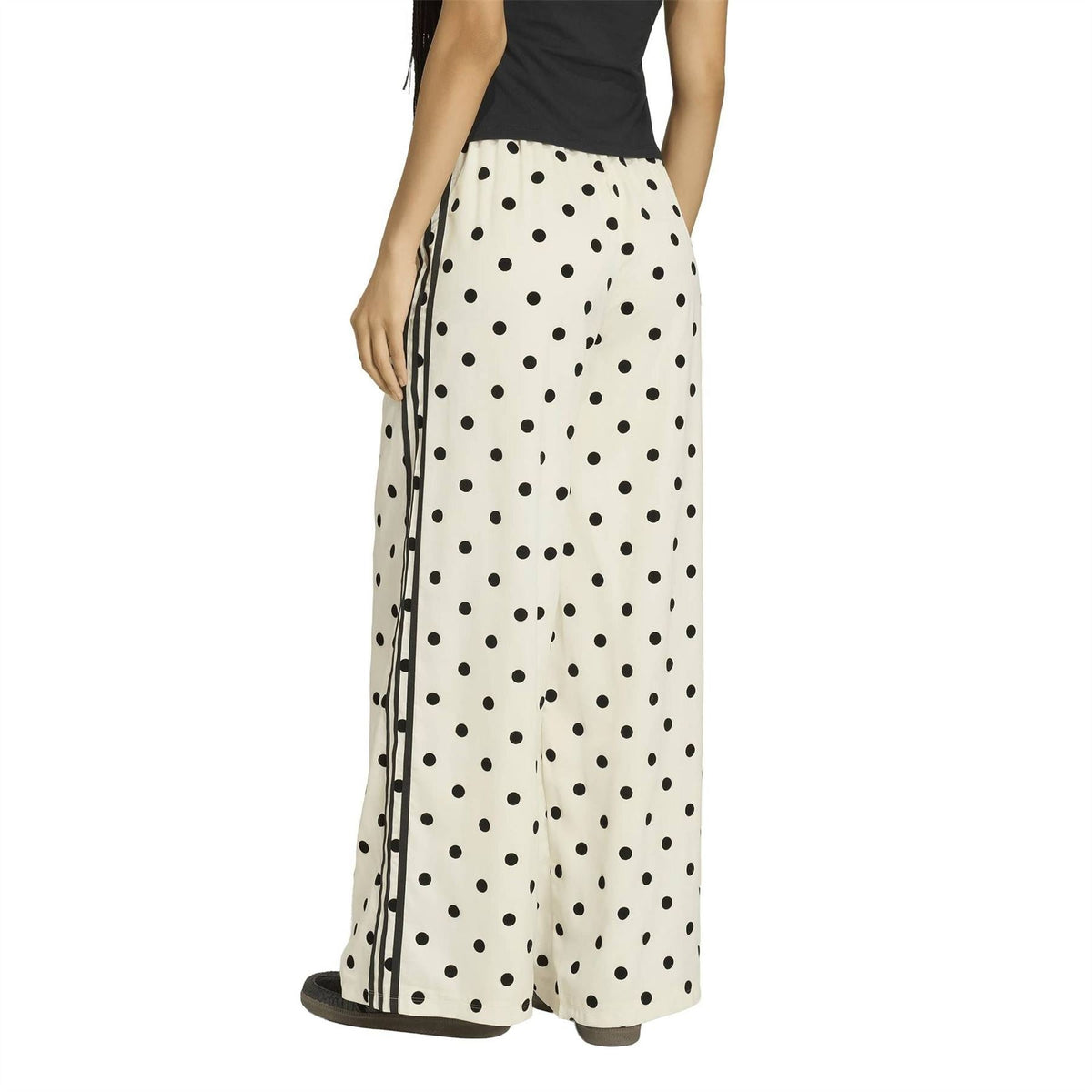 Off-white wide-leg pants with black polka dots and elastic waist, shown from the side