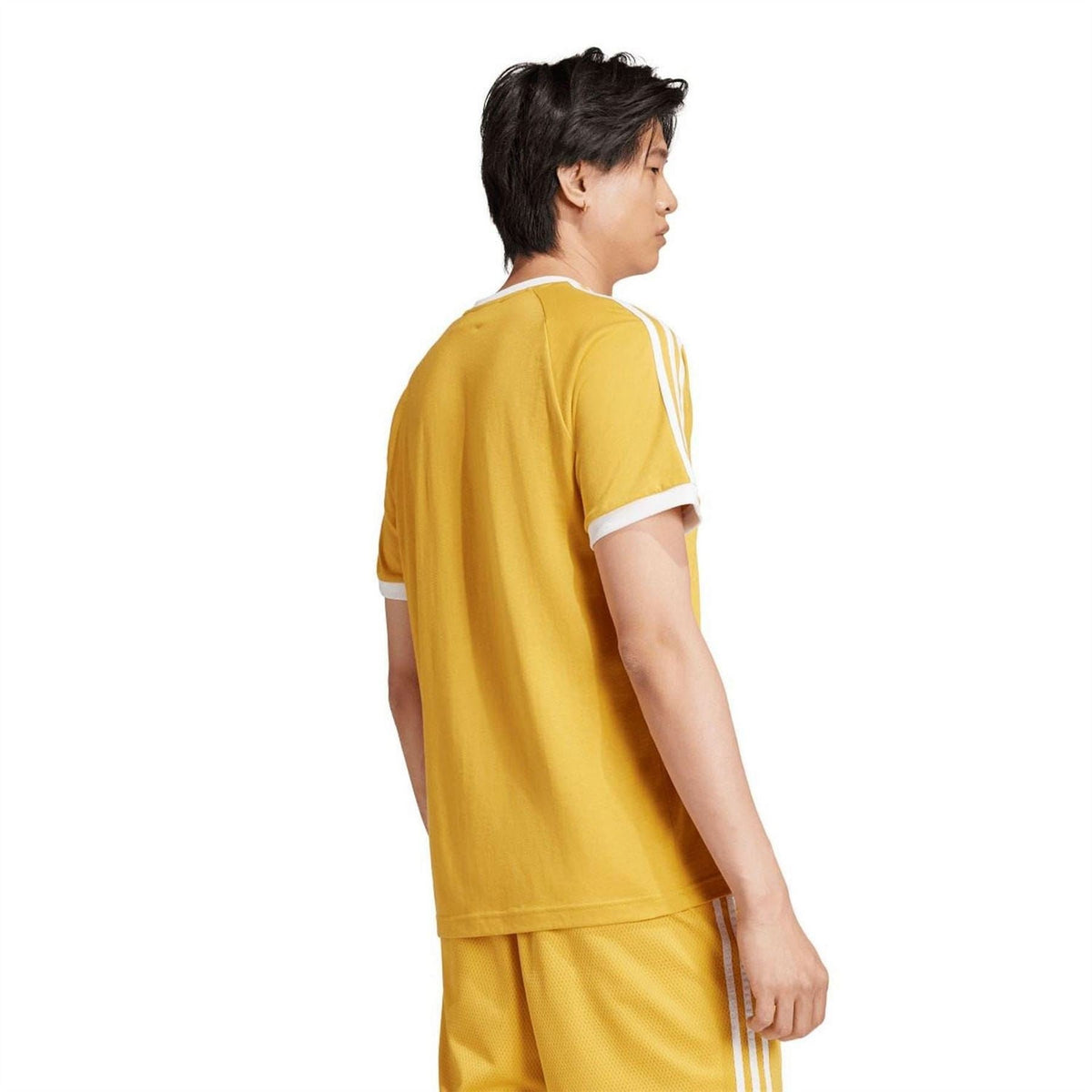Yellow adidas T-shirt back view with white collar trim and three-stripe sleeve detail