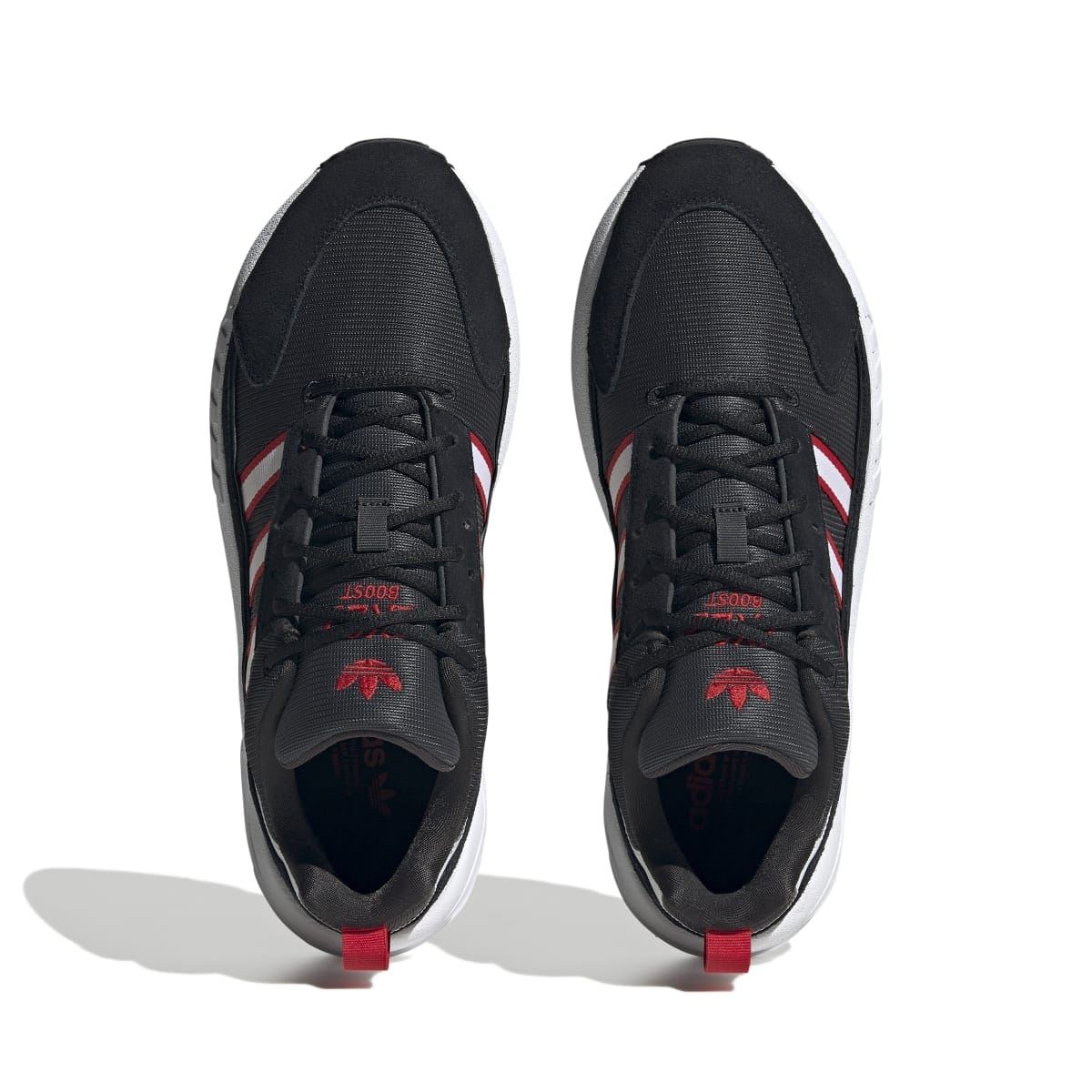 Pair of black ZX 22 Boost trainers from toe view with red logo details on tongue