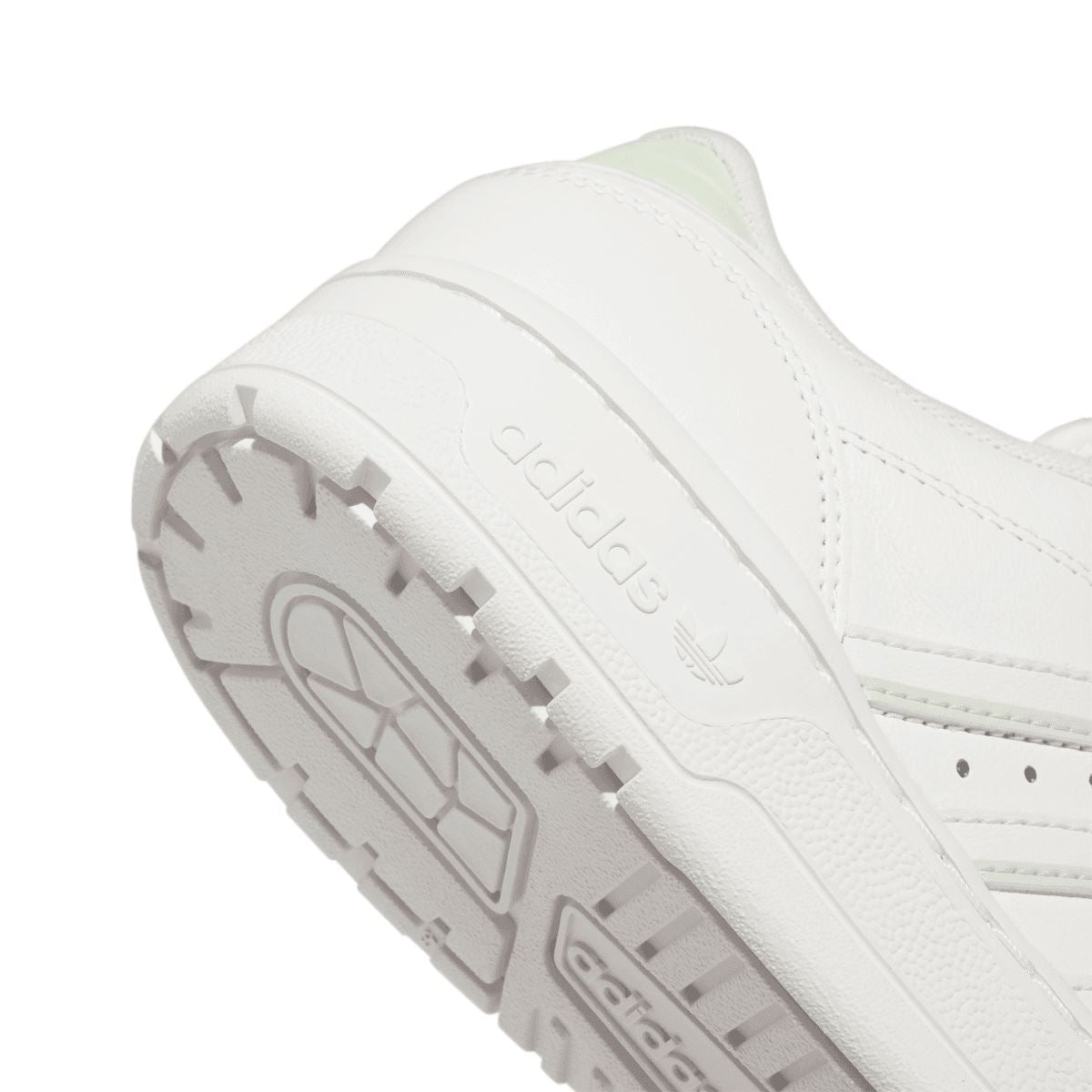 Close-up of white trainer outsole and heel, showing tread pattern and adidas branding