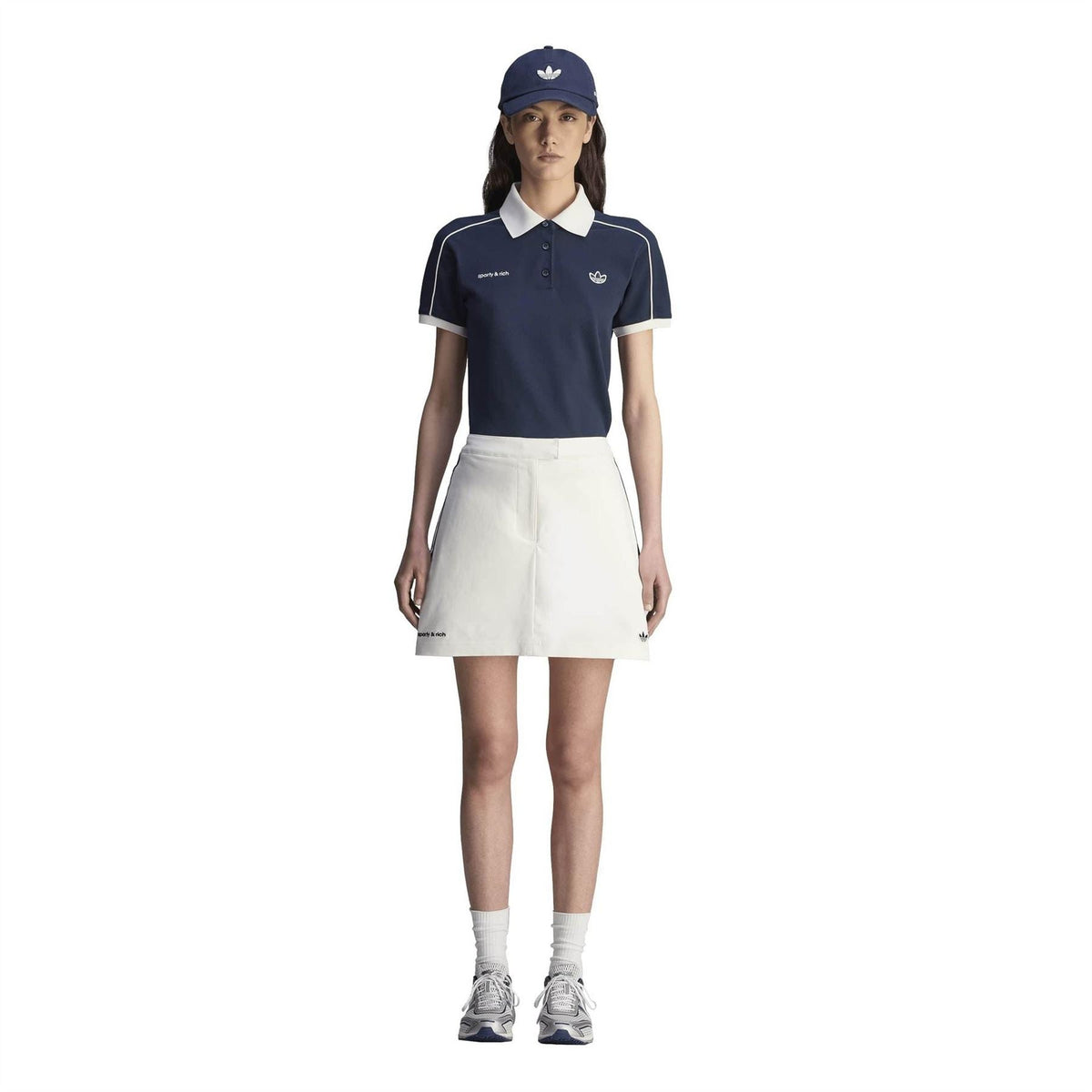 Sporty & Rich skirt worn with navy polo, Core White A-line mini skirt