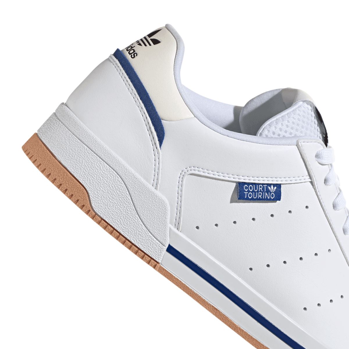 Close-up of white adidas court-style trainer with blue stripe, laces, and perforated toe