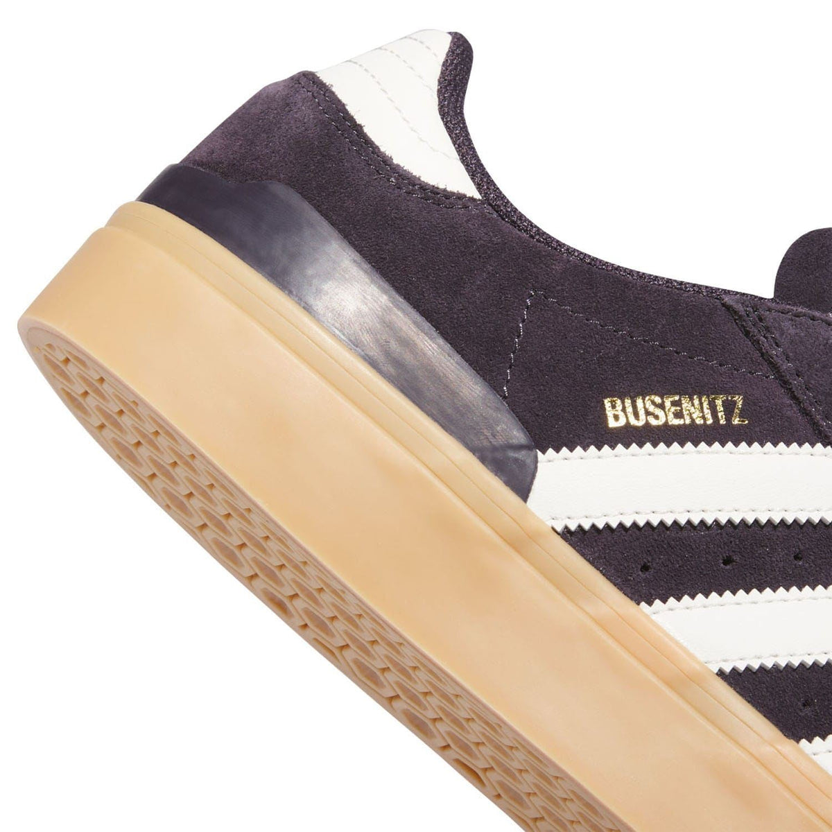 Heel and side view of dark suede trainer with BUSENITZ detail and gum sole