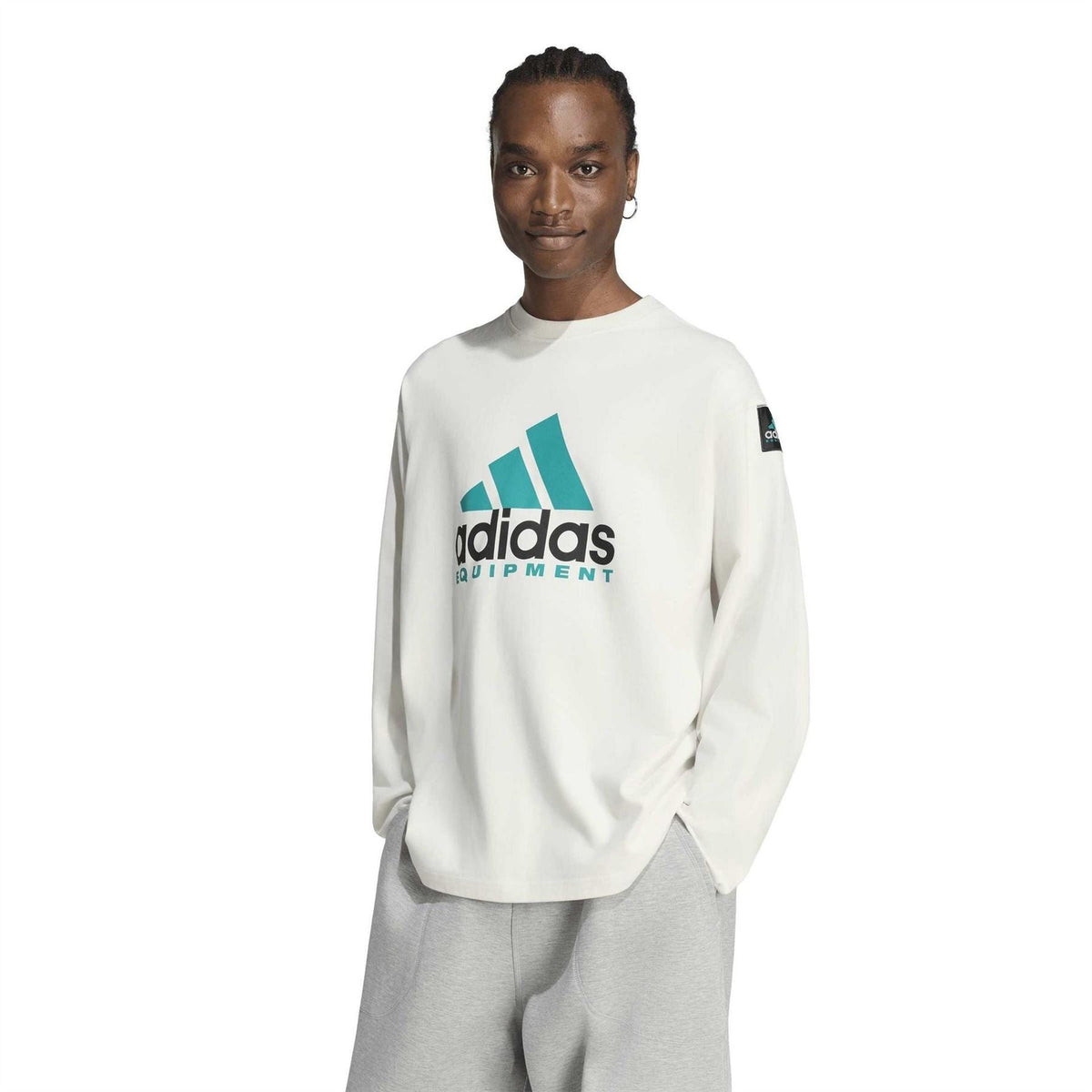 Off-white long-sleeve top with teal adidas Equipment logo and crew neckline