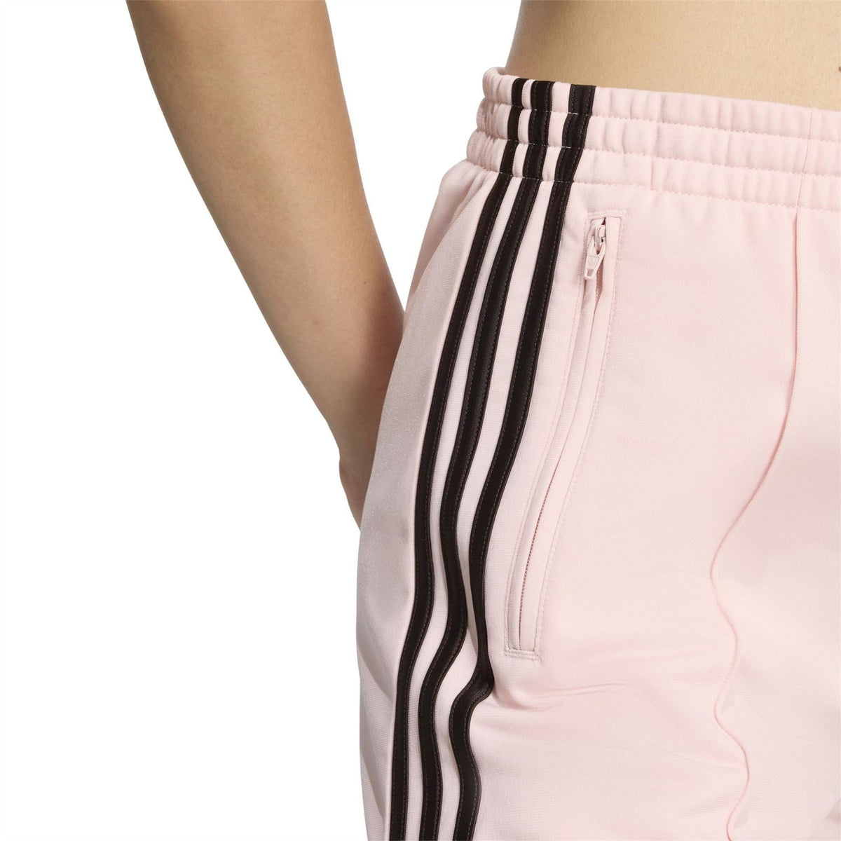 Light pink shorts close-up: elastic waist, front zip pocket, and black side stripe trim