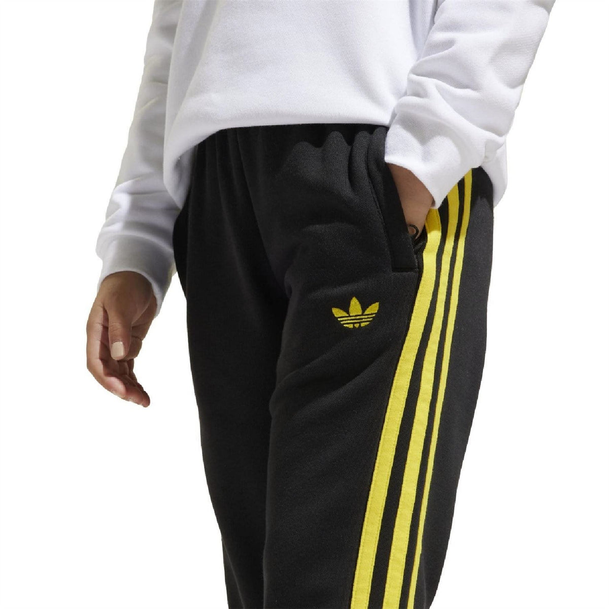 Black track pants with yellow side stripes and small yellow logo on the thigh