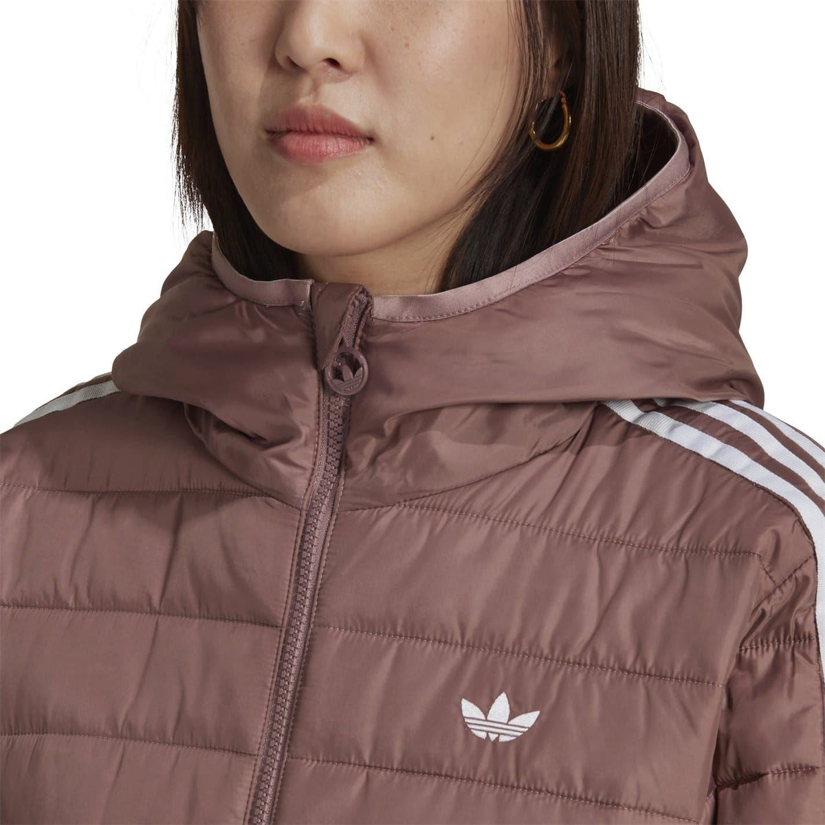 Hooded puffer jacket close-up with drawstring hood and trefoil emblem