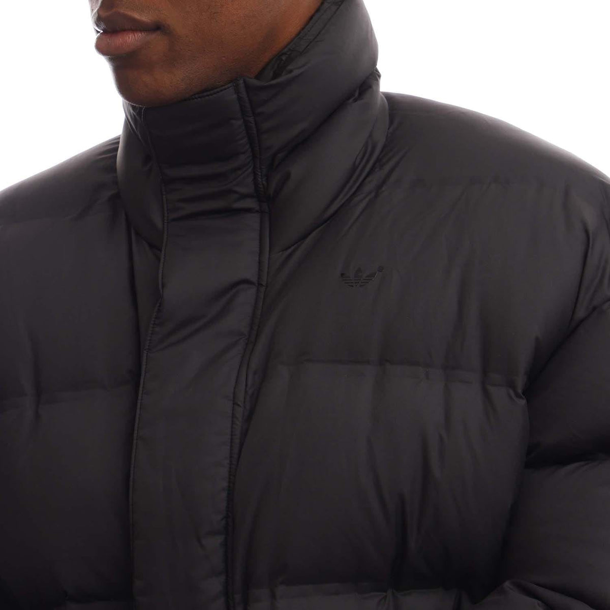 Black down puffer jacket front close-up with zip placket and small chest logo