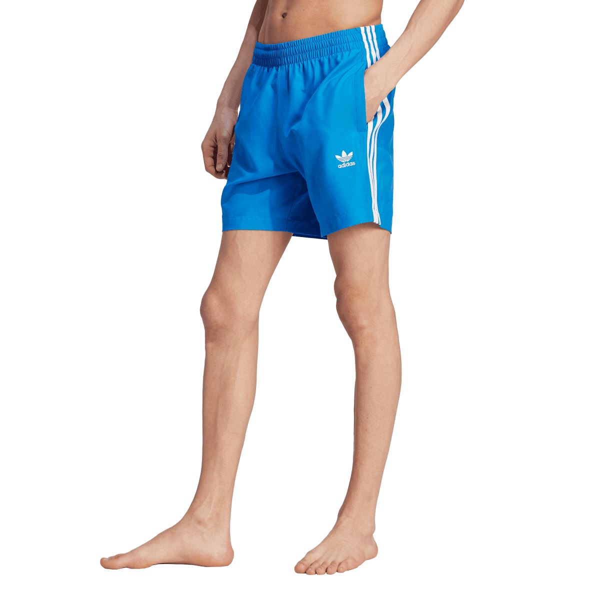 Blue adidas swim shorts on model, showing elastic waist and side stripe detail
