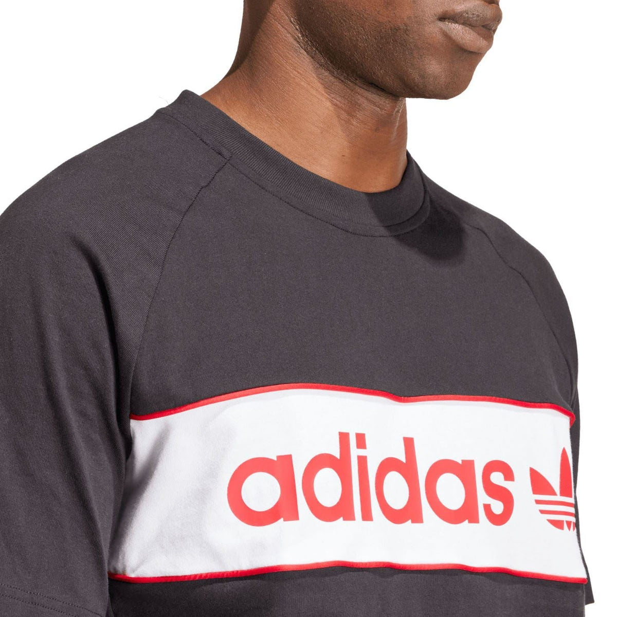 Black T-shirt close-up: red-and-white adidas logo band across chest