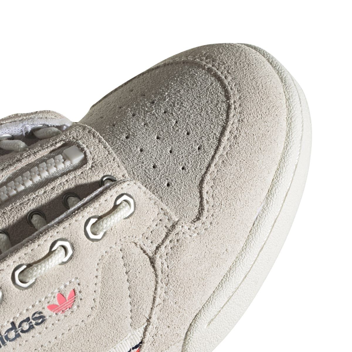 Close-up of light beige suede toe with perforation details and lace hardware