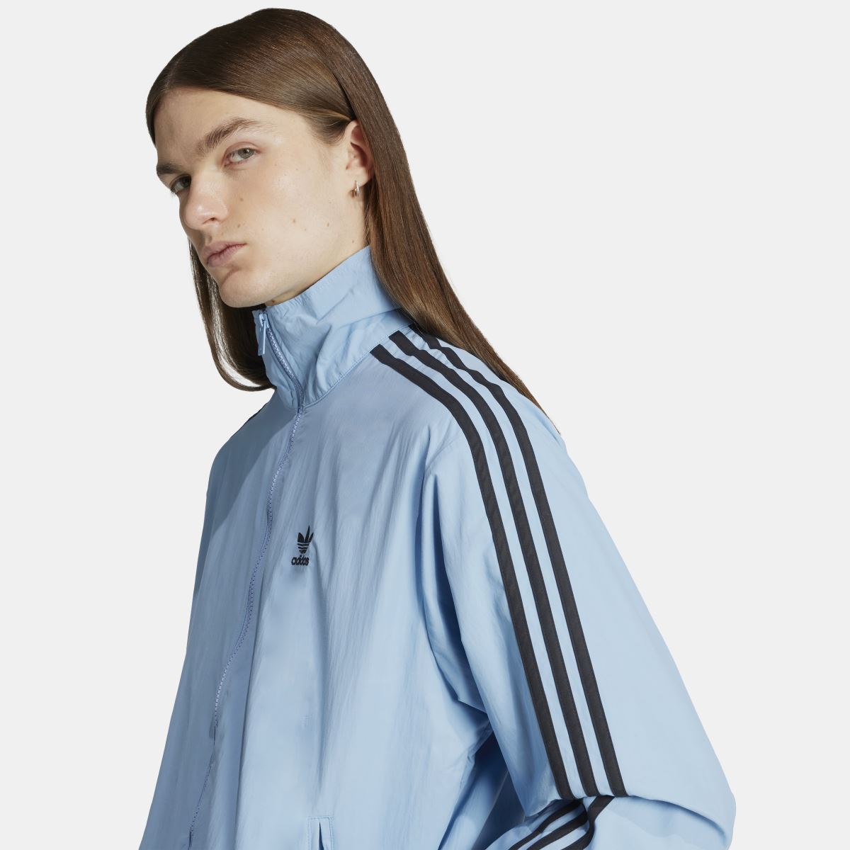 Light blue track jacket detail with adidas logo on chest and black triple stripe shoulder