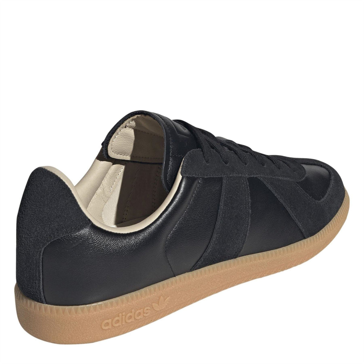 Side view of black adidas Originals low-top sneakers with cream lining and gum sole