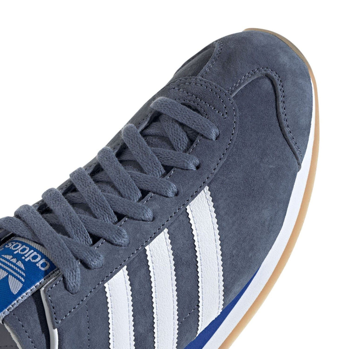 Navy suede upper close-up with grey laces and white three adidas stripes