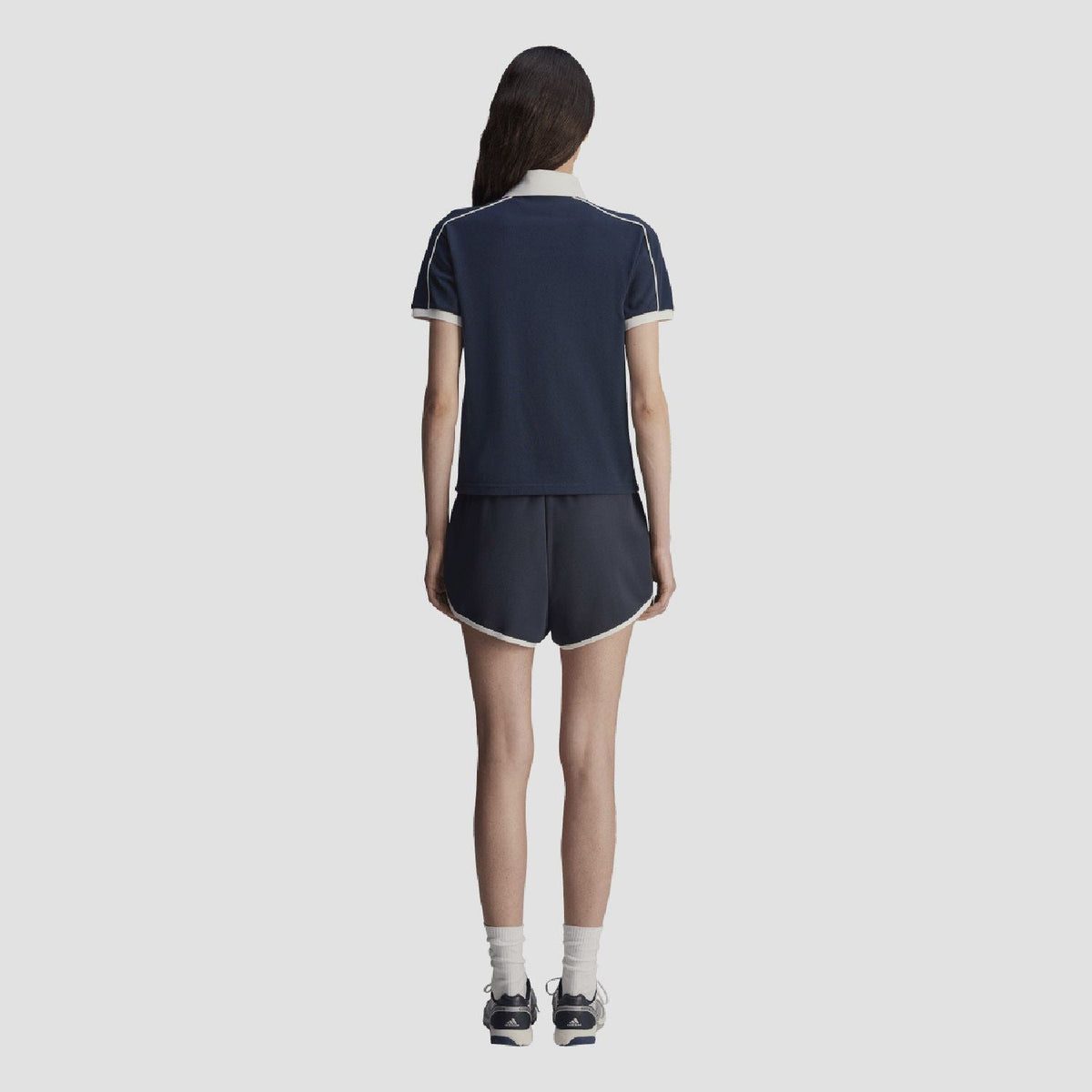 Navy polo shirt back view with white piping at shoulders and sleeve cuffs