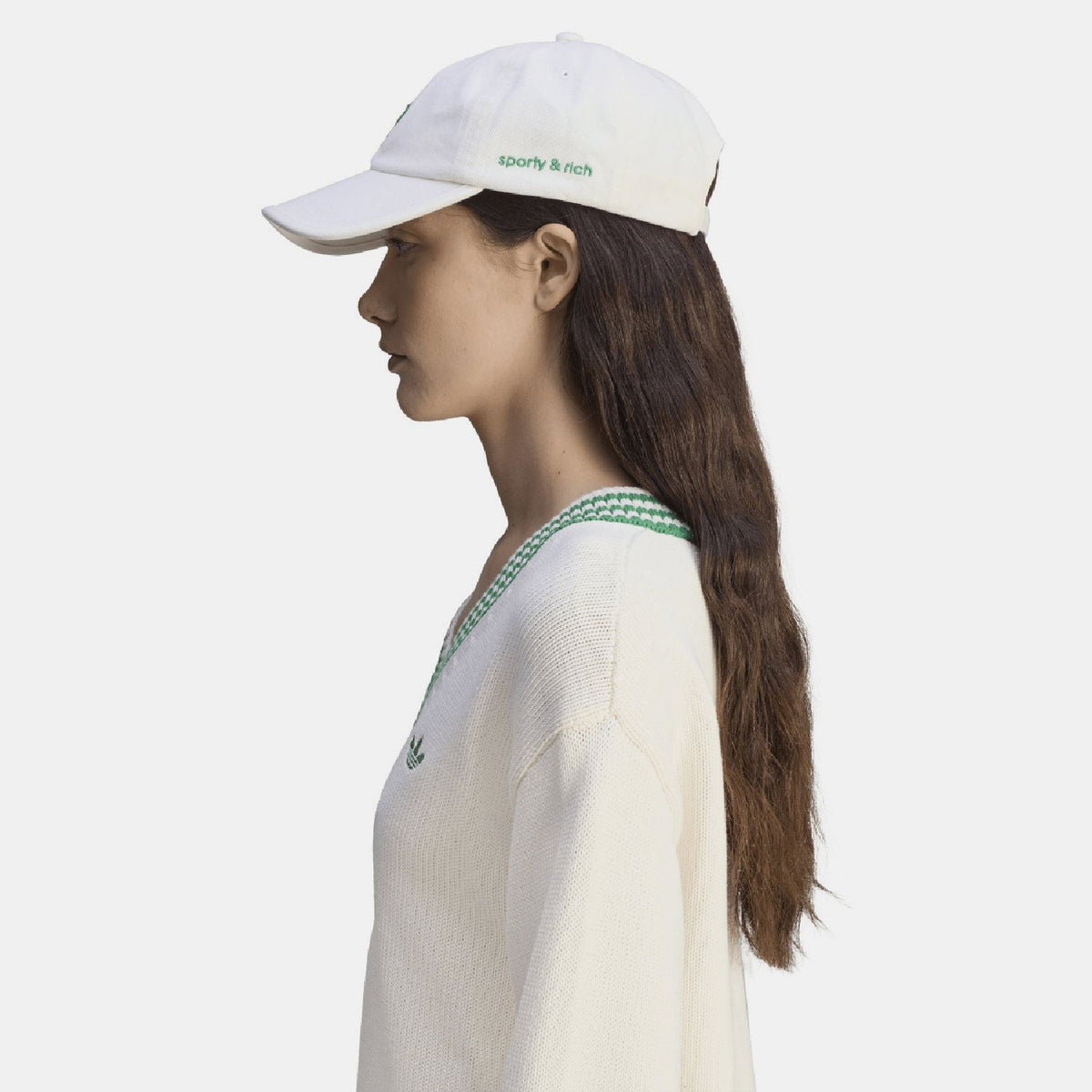 White cap worn by model, featuring green trefoil and 'sporty & rich' on back