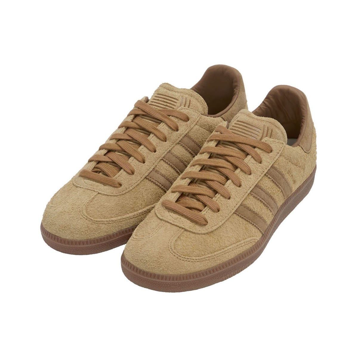 Brown suede Samba style trainers, side view with lace-up eyelets and gum sole